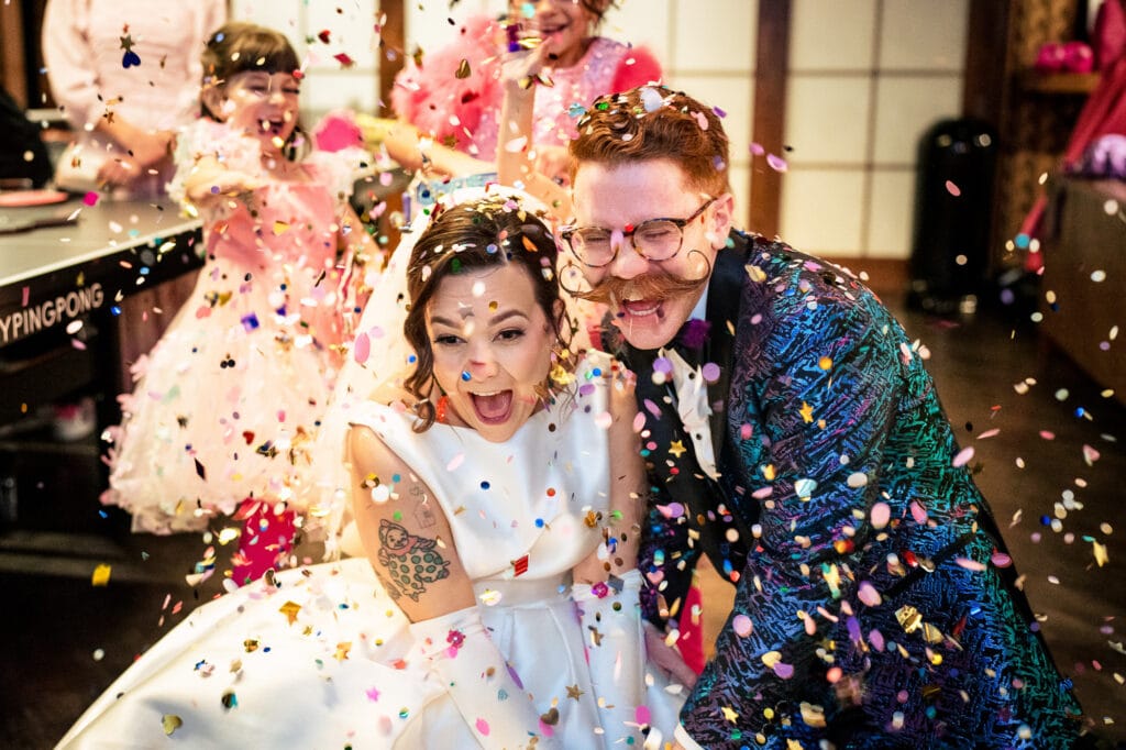 During their Phoenix Arizona wedding a couple is showered with confetti by the flower girls.